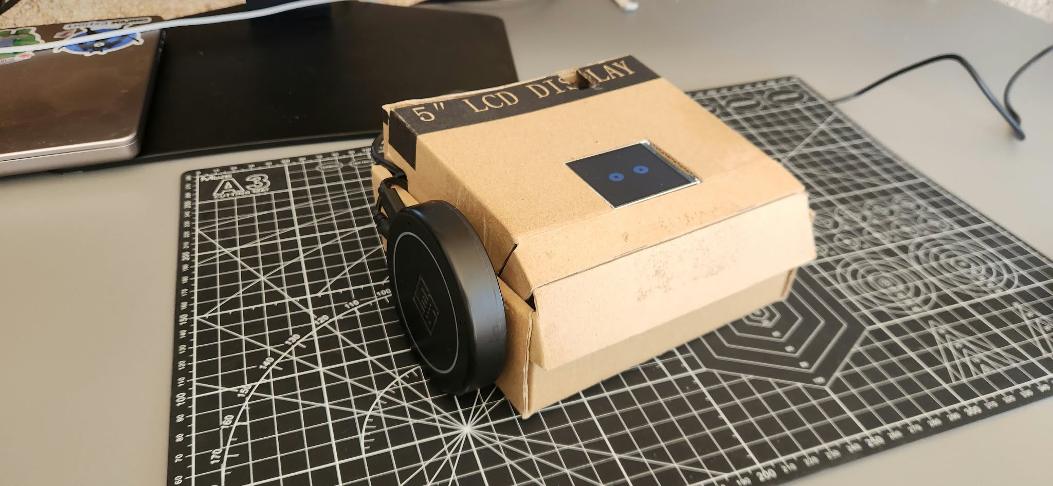 Prototipo físico actual de MILO, montado en una carcasa de cartón con pantalla frontal y altavoz lateral.